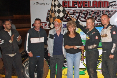 Chris Wall (with flag) and other drivers made donations to track workers Betty and Jerry Morris. (Ronnie Barnett)