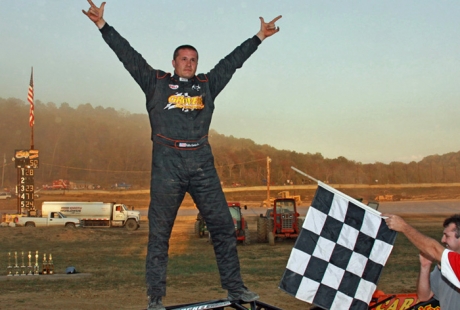 Eddie Carrier Jr. celebrates atop his roofless car. (rasmithphoto.com)